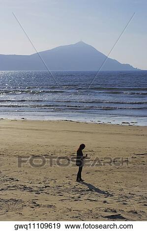 Stock Photo - High angle view of a woman standing on the beach. Fotosearch