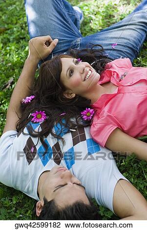 High angle view of a young couple lying in a park View Large Photo Image Stock Image - High angle view of a young couple lying in a park. Fotosearch
