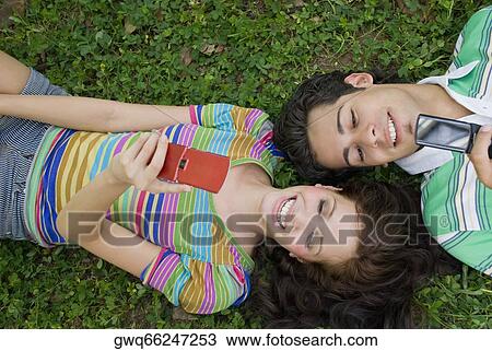 High angle view of a young couple lying in a park View Large Photo Image Stock Image - High angle view of a young couple lying in a park. Fotosearch