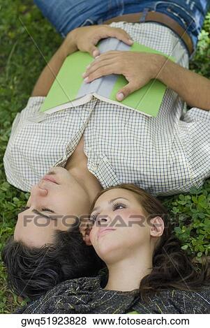 High angle view of a young couple lying in a park View Large Photo Image Stock Photo - High angle view of a young couple lying in a park. Fotosearch