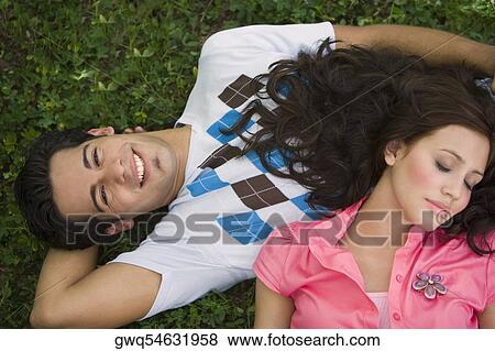 High angle view of a young couple lying in a park View Large Photo Image Stock Photo - High angle view of a young couple lying in a park. Fotosearch