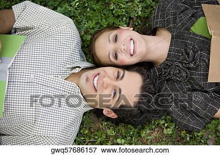 High angle view of a young couple lying in a park View Large Photo Image Stock Photo - High angle view of a young couple lying in a park. Fotosearch
