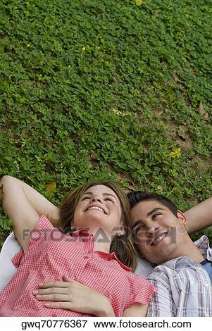 High angle view of a young couple lying in a park and smiling View Large Photo Image Stock Photo - High angle view of a young couple lying in a park and smiling. Fotosearch