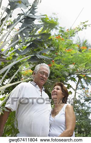 Low angle view of a senior couple standing together View Large Photo Image Picture - Low angle view of a senior couple standing together. Fotosearch