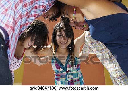 Low angle view of five friends standing in a huddle and smiling View Large Photo Image Stock Photograph - Low angle view of five friends standing in a huddle and smiling. Fotosearch