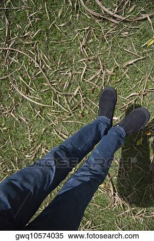 Low section view of a person's feet hanging over a lawn View Large Photo Image Stock Photography - Low section view of a person's feet hanging over a lawn. Fotosearch