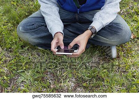 Low section view of a teenage boy using a mobile phone View Large Photo Image Stock Image - Low section view of a teenage boy using a mobile phone. Fotosearch