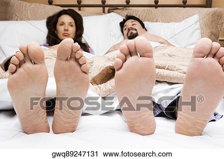 Mid adult couple lying on the bed View Large Photo Image Stock Image - Mid adult couple lying on the bed. Fotosearch
