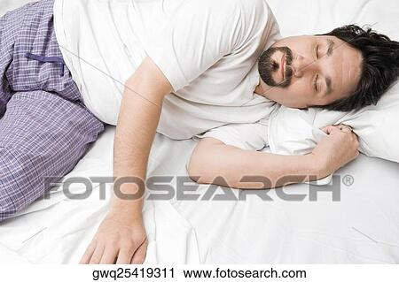 Mid adult man sleeping on the bed View Large Photo Image Stock Image - Mid adult man sleeping on the bed. Fotosearch