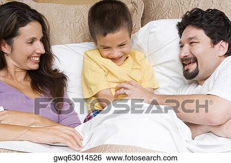 Mid adult man tickling his son with a mid adult woman looking at them View Large Photo Image Stock Photograph - Mid adult man tickling his son with a mid adult woman looking at them. Fotosearch