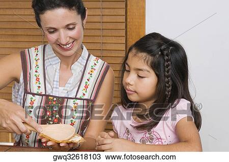 Mid adult woman preparing bread with her daughter in the kitchen View Large Photo Image Stock Image - Mid adult woman preparing bread with her daughter in the kitchen. Fotosearch