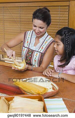 Mid adult woman preparing bread with her daughter in the kitchen View Large Photo Image Stock Photo - Mid adult woman preparing bread with her daughter in the kitchen. Fotosearch
