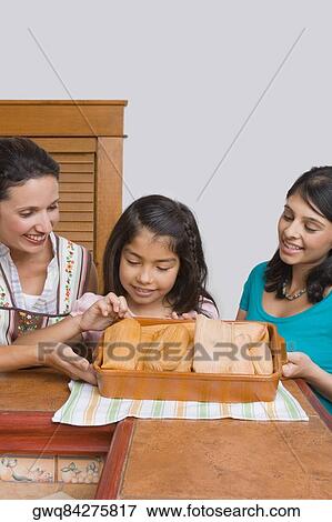Mid adult woman with her two daughters smiling with a tray of breads in the kitchen View Large Photo Image Stock Photo - Mid adult woman with her two daughters smiling with a tray of breads in the kitchen. Fotosearch