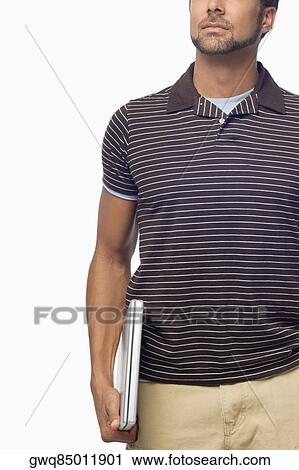 Stock Image - Mid section view of a mid adult man holding a laptop. Fotosearch
