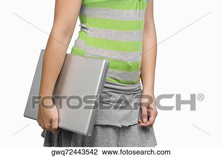 Mid section view of a woman holding a laptop View Large Photo Image Stock Image - Mid section view of a woman holding a laptop. Fotosearch