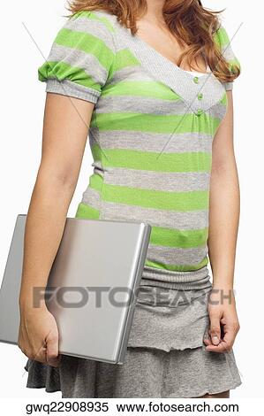 Mid section view of a woman holding a laptop View Large Photo Image Stock Photography - Mid section view of a woman holding a laptop. Fotosearch