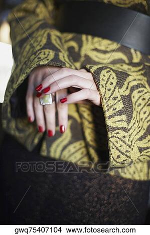 Mid section view of a woman wearing a ring View Large Photo Image Picture - Mid section view of a woman wearing a ring. Fotosearch