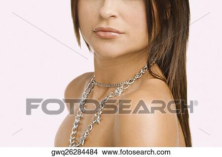 Mid section view of a young woman wearing a necklace View Large Photo Image Picture - Mid section view of a young woman wearing a necklace. Fotosearch