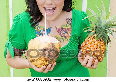 Mid section view of a young woman holding a pineapple and drinking coconut milk with a drinking straw View Large Photo Image Stock Image - Mid section view of a young woman holding a pineapple and drinking coconut milk with a drinking straw. Fotosearch
