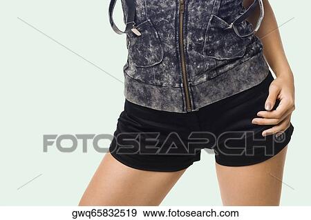 Mid section view of a young woman standing with her hand on her hip View Large Photo Image Stock Photo - Mid section view of a young woman standing with her hand on her hip. Fotosearch