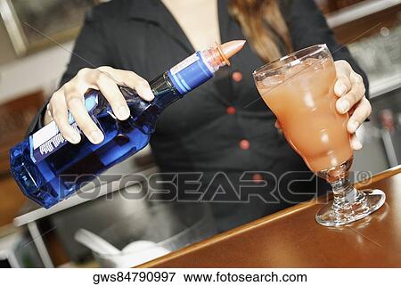 Mid section view of a young woman making a cocktail View Large Photo Image Stock Photo - Mid section view of a young woman making a cocktail. Fotosearch