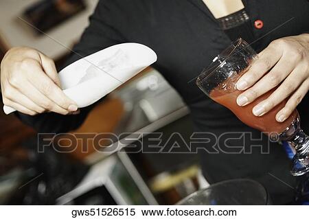 Mid section view of a young woman putting ice cubes into a glass with a scoop View Large Photo Image Stock Photography - Mid section view of a young woman putting ice cubes into a glass with a scoop. Fotosearch