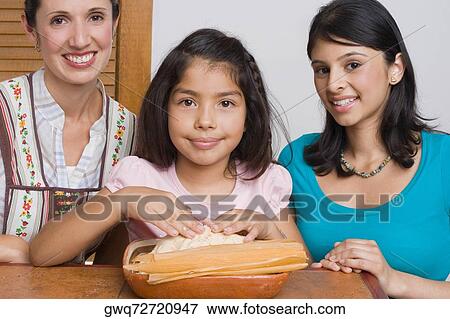 Portrait of a girl preparing bread with her mother and sister in the kitchen View Large Photo Image Stock Photo - Portrait of a girl preparing bread with her mother and sister in the kitchen. Fotosearch