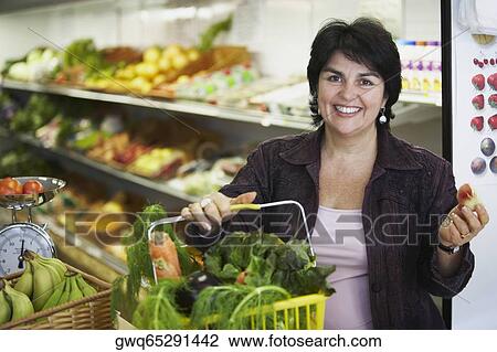 Portrait of a mature woman holding a shopping basket and smiling View Large Photo Image Stock Image - Portrait of a mature woman holding a shopping basket and smiling. Fotosearch