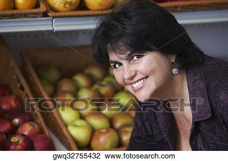 Stock Image - Portrait of a mature woman shopping in a grocery store. Fotosearch