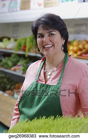 Portrait of a mature woman standing in a grocery store and smiling View Large Photo Image Stock Image - Portrait of a mature woman standing in a grocery store and smiling. Fotosearch