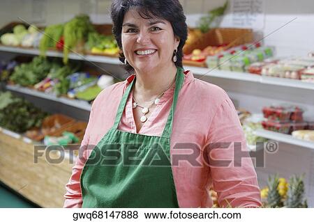 Portrait of a mature woman standing in a grocery store and smiling View Large Photo Image Stock Photo - Portrait of a mature woman standing in a grocery store and smiling. Fotosearch