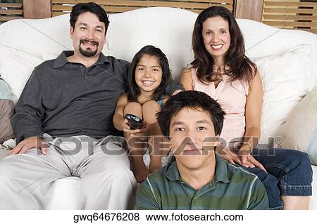 Portrait of a mid adult couple watching television with their son and daughter View Large Photo Image Stock Photo - Portrait of a mid adult couple watching television with their son and daughter. Fotosearch