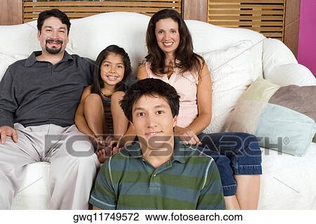 Stock Image - Portrait of a mid adult couple with their son and daughter. Fotosearch