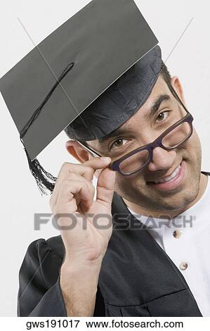 Stock Photo - Portrait of a mid adult man adjusting his eyeglasses and smiling. Fotosearch