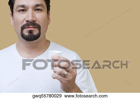 Stock Photo - Portrait of a mid adult man holding a cup of mouthwash. Fotosearch