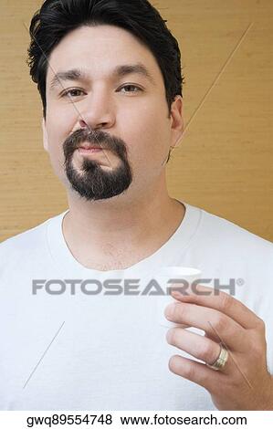 Portrait of a mid adult man holding a cup of mouthwash and rinsing his mouth with mouthwash View Large Photo Image Stock Photo - Portrait of a mid adult man holding a cup of mouthwash and rinsing his mouth with mouthwash. Fotosearch