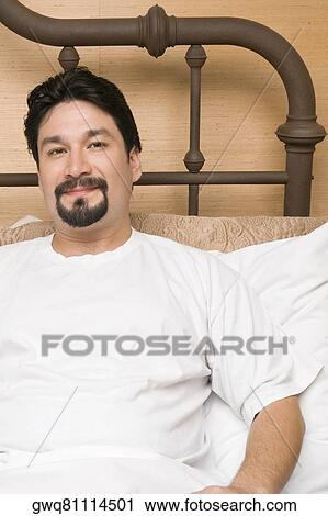 Portrait of a mid adult man reclining on the bed View Large Photo Image Stock Image - Portrait of a mid adult man reclining on the bed. Fotosearch