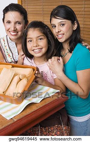 Portrait of a mid adult woman and her two daughters smiling with a tray of breads in the kitchen View Large Photo Image Stock Photography - Portrait of a mid adult woman and her two daughters smiling with a tray of breads in the kitchen. Fotosearch