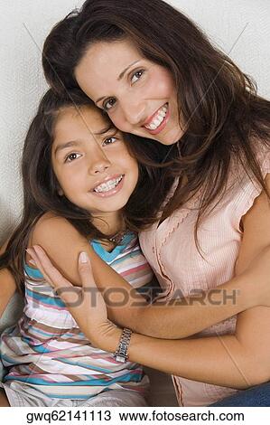 Stock Image - Portrait of a mid adult woman hugging her daughter. Fotosearch