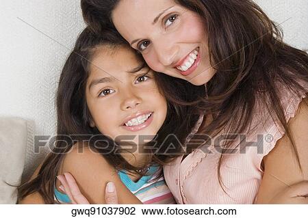 Portrait of a mid adult woman hugging her daughter View Large Photo Image Stock Image - Portrait of a mid adult woman hugging her daughter. Fotosearch