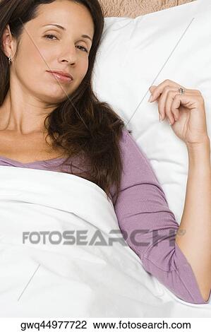 Portrait of a mid adult woman lying on the bed View Large Photo Image Stock Image - Portrait of a mid adult woman lying on the bed. Fotosearch