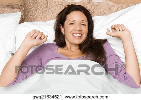 Portrait of a mid adult woman waking up and smiling View Large Photo Image Stock Image - Portrait of a mid adult woman waking up and smiling. Fotosearch