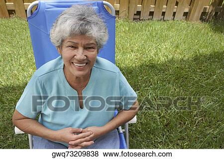 Portrait of a senior woman sitting in a lawn chair and smiling View Large Photo Image Stock Photo - Portrait of a senior woman sitting in a lawn chair and smiling. Fotosearch