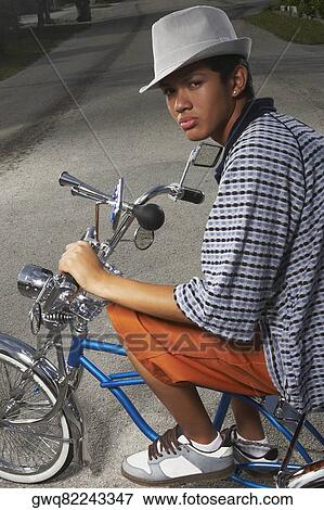 Portrait of a teenage boy cycling on a low rider bicycle View Large Photo Image Stock Photo - Portrait of a teenage boy cycling on a low rider bicycle. Fotosearch