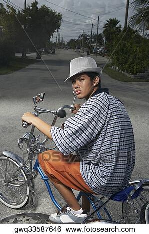 Portrait of a teenage boy cycling on a low rider bicycle View Large Photo Image Stock Photograph - Portrait of a teenage boy cycling on a low rider bicycle. Fotosearch