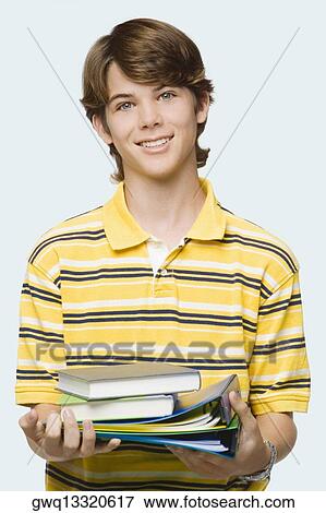 Portrait of a teenage boy holding books and ring binders View Large Photo Image Stock Photo - Portrait of a teenage boy holding books and ring binders. Fotosearch