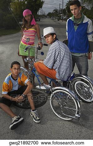 Portrait of a teenage boy on a low rider bicycle with his three friends beside him View Large Photo Image Stock Image - Portrait of a teenage boy on a low rider bicycle with his three friends beside him. Fotosearch