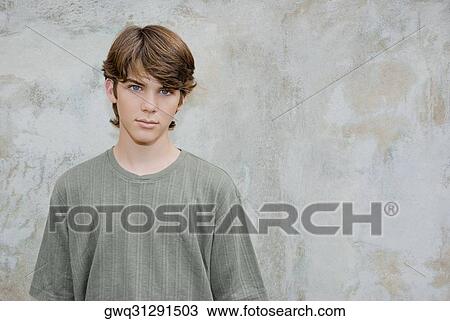 Portrait of a teenage boy standing in front of a wall View Large Photo Image Stock Image - Portrait of a teenage boy standing in front of a wall. Fotosearch