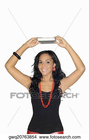 Portrait of a teenage girl holding a book above her head View Large Photo Image Picture - Portrait of a teenage girl holding a book above her head. Fotosearch