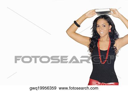Stock Photo - Portrait of a teenage girl holding a book on her head. Fotosearch